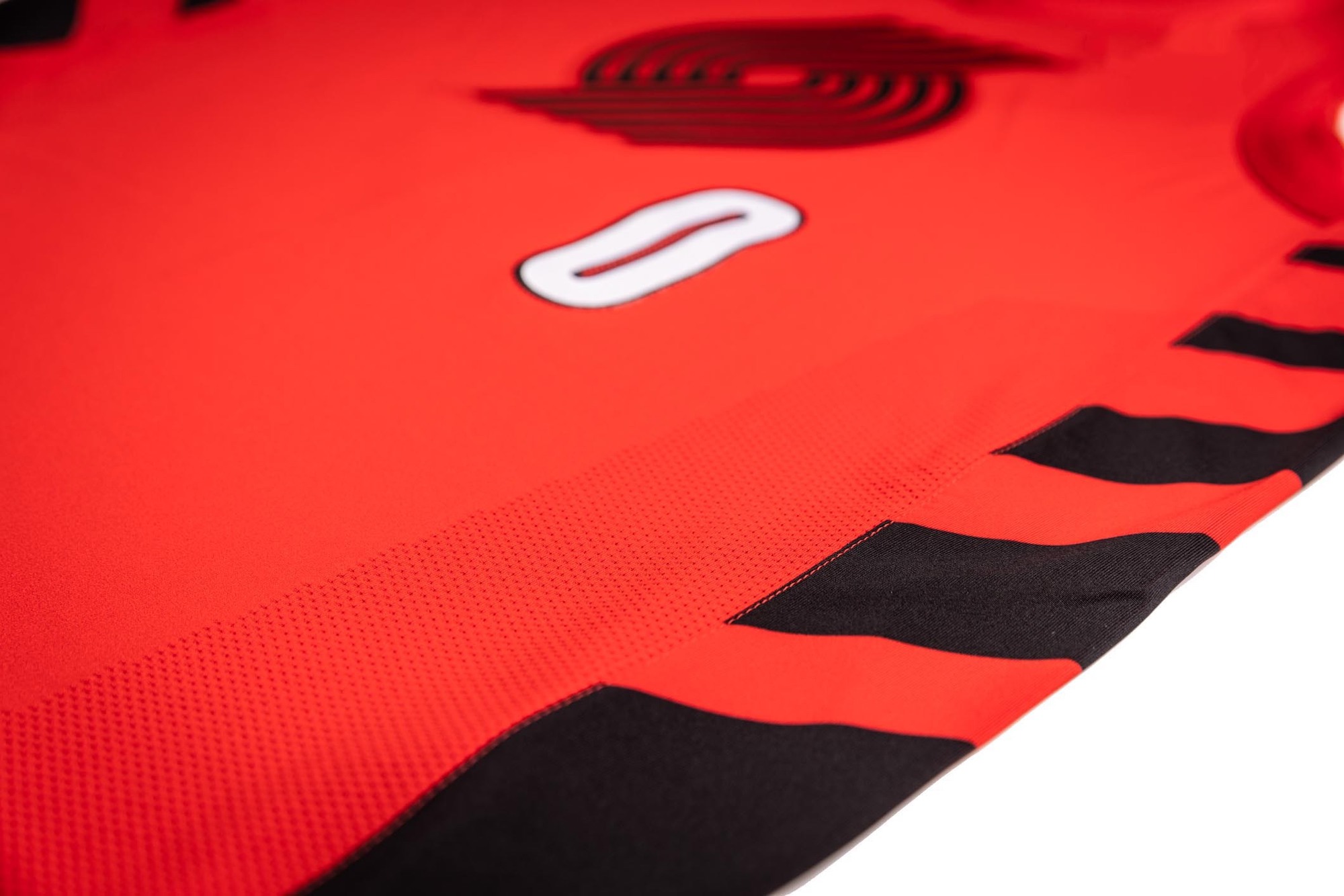 It is a bold red-base uniform with trim and design detail accents of additional team colors including black and white.